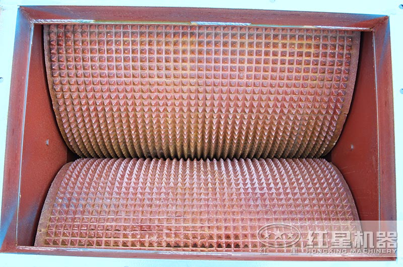 相向轉(zhuǎn)動(dòng)的兩輥?zhàn)?，調(diào)節(jié)其間隙可改變出料